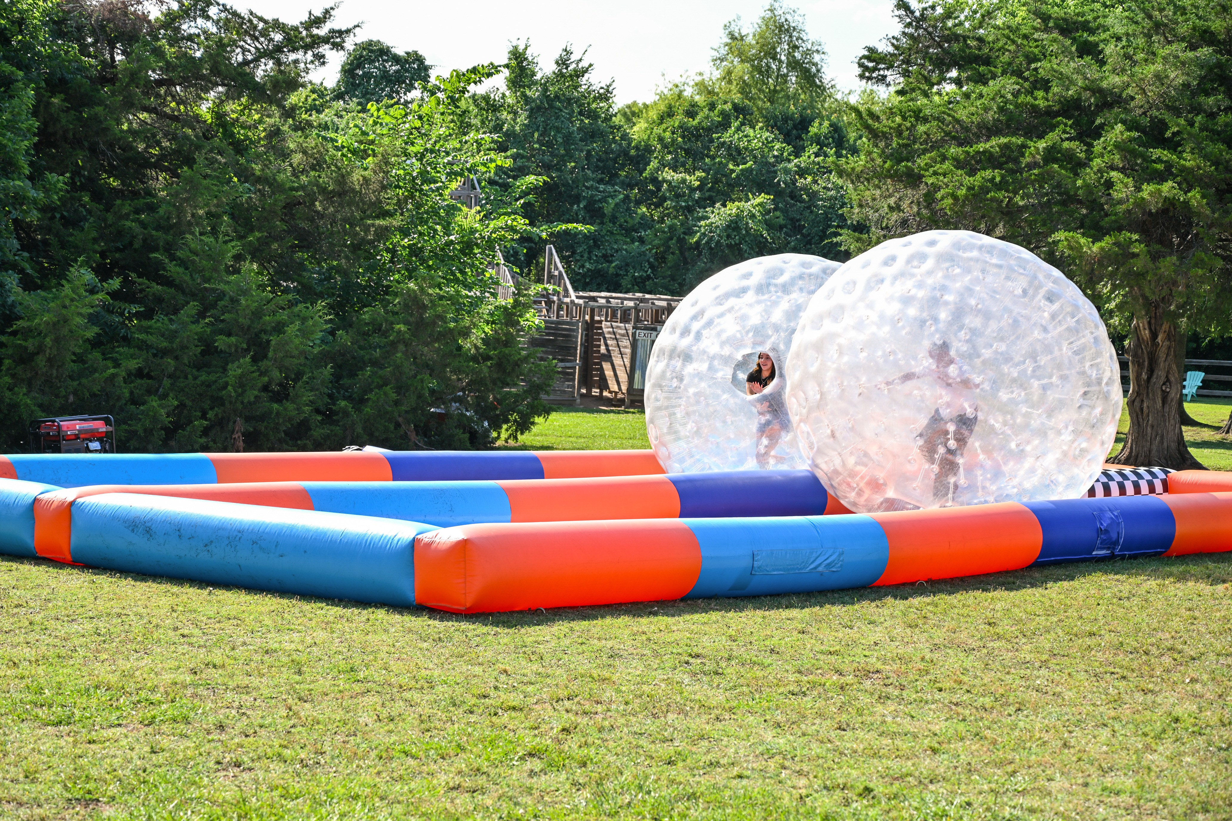 Campers rolling inside giant zorb balls on an inflatable track at Circle R Ranch